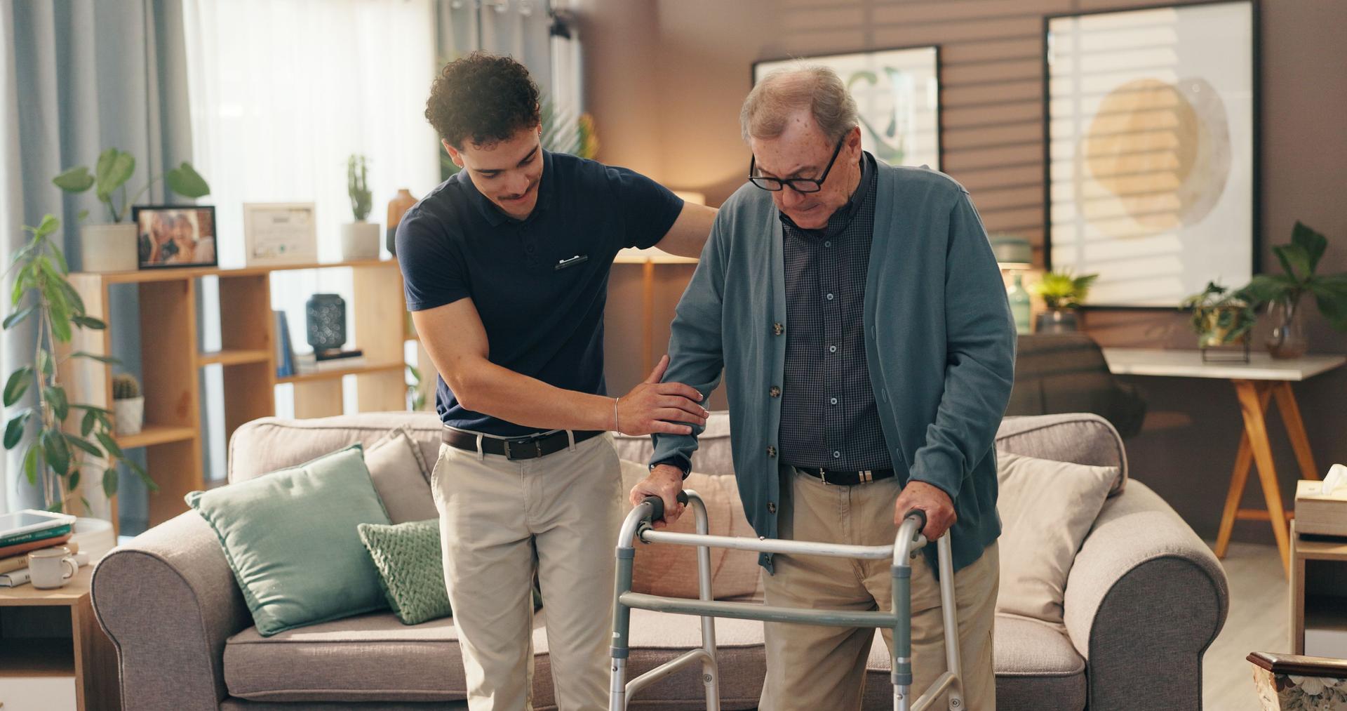 Old man, caregiver and help with walker in home for mobility support, assistance or rehabilitation. Health worker, senior person and walking guide in assisted living facility for balance and recovery